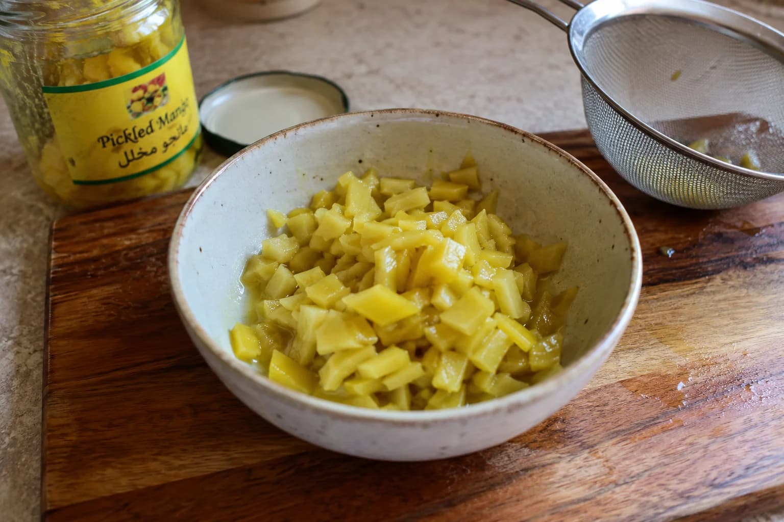 Tangy pickled mango pieces prepared for making authentic Iraqi amba sauce.