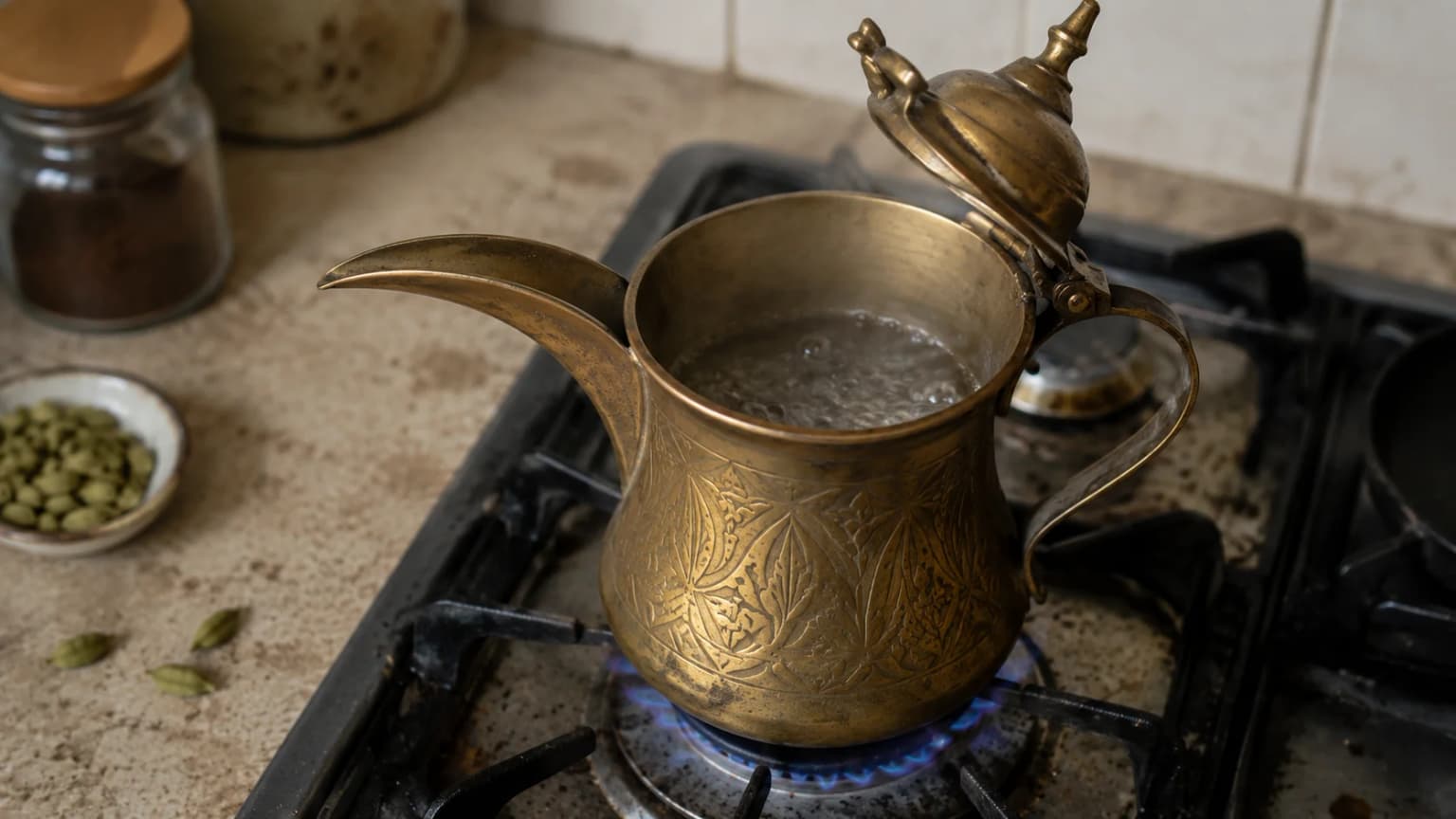 Water heating gently in a traditional coffee pot for Arabic coffee.
