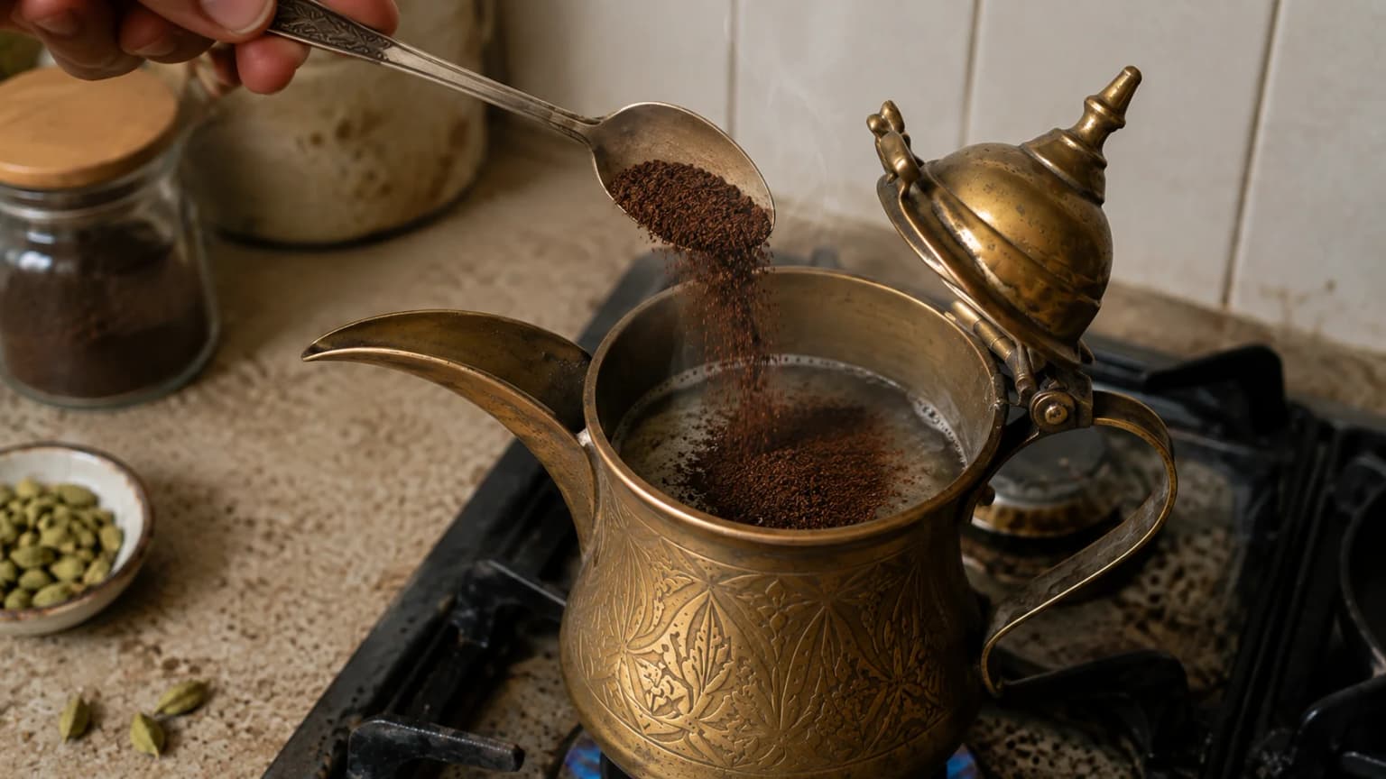 Finely ground Arabic coffee being added to hot water in a traditional coffee pot.