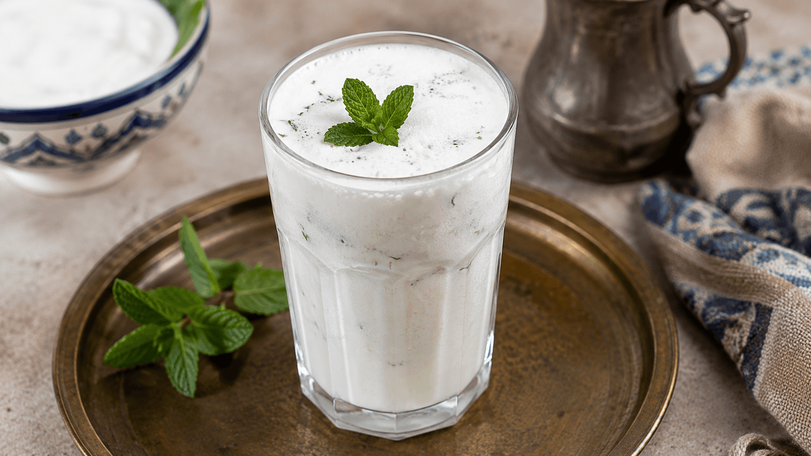 A chilled glass of traditional Lebanese Ayran garnished with fresh mint and served with ice.