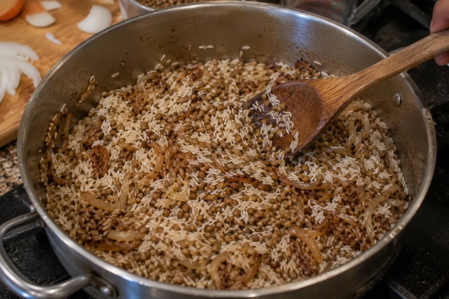 Nearly tender lentils and rinsed rice being combined with seasoned caramelized onions for Mujadara.