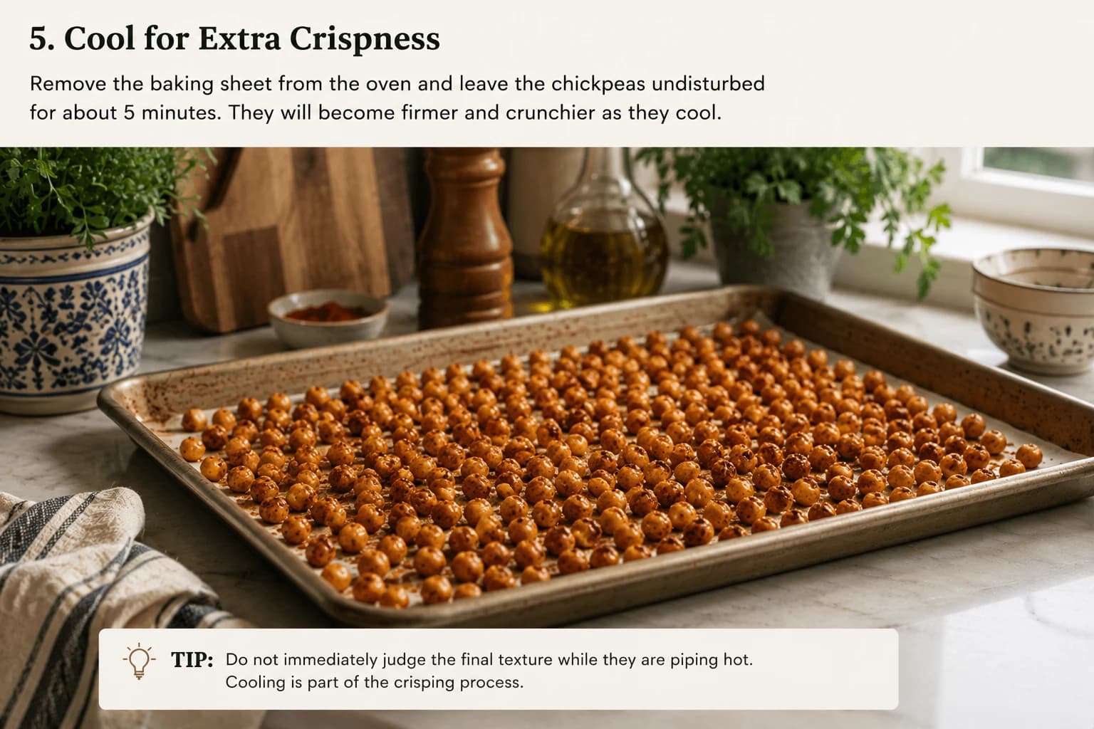 Freshly roasted golden chickpeas cooling on a baking sheet in a stylish kitchen.